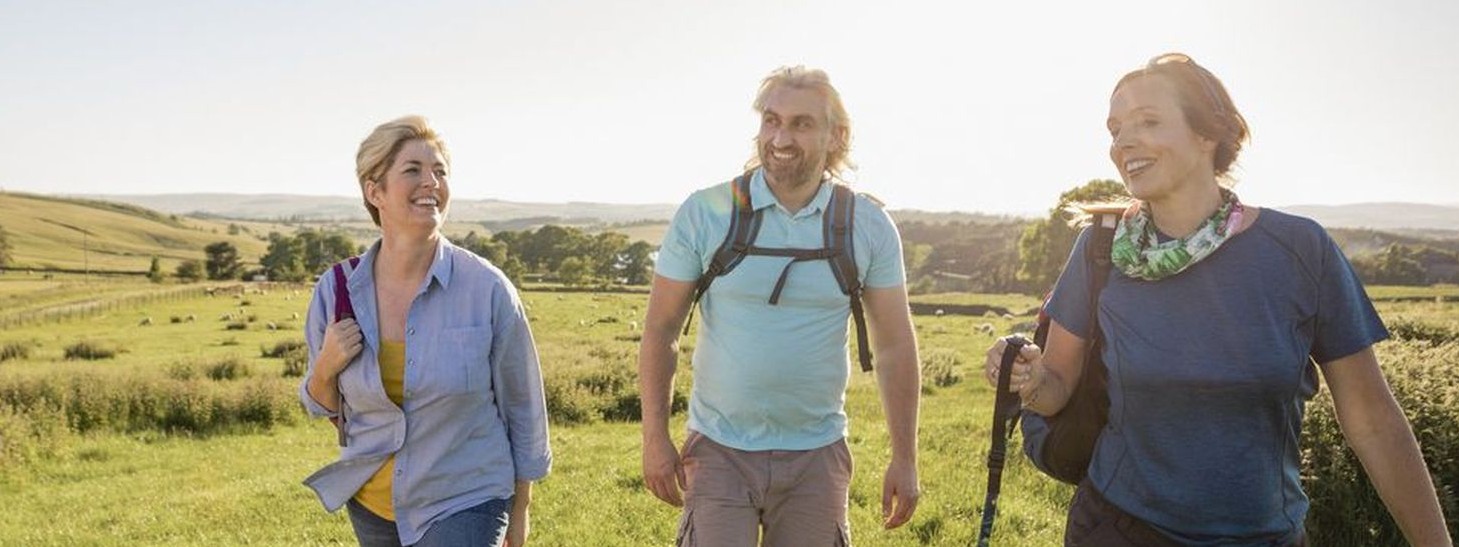 Zwei Frauen und ein Mann mittleren Alters beteiligen sich am Wandern mit Herzblut