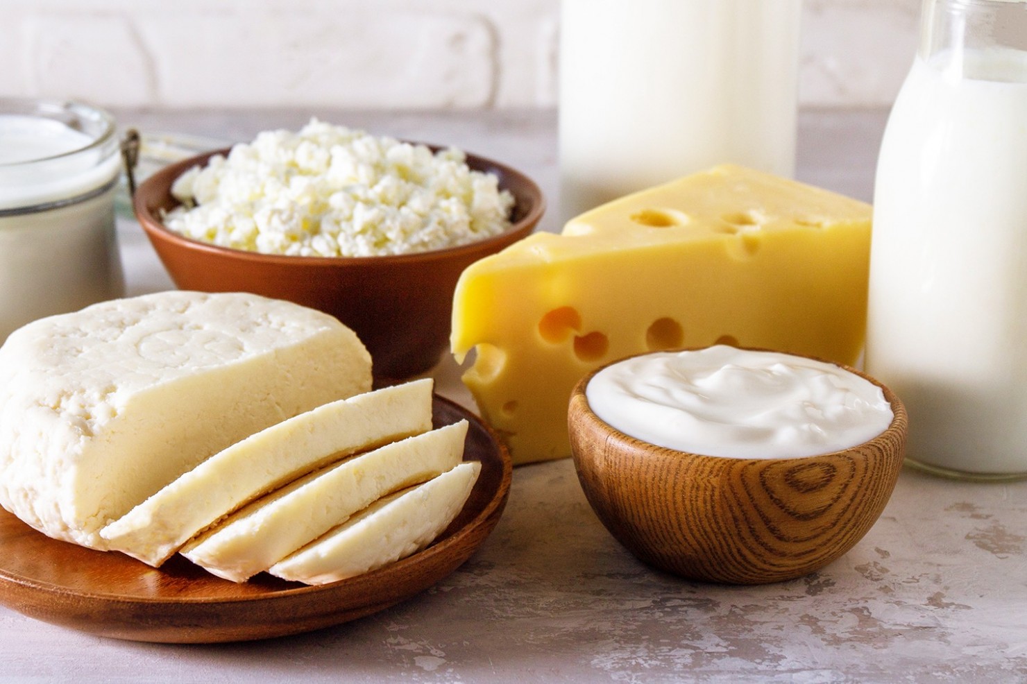  Verschiedene Milchprodukte wie Käse, Quark und Milch stehen auf einem Tisch.