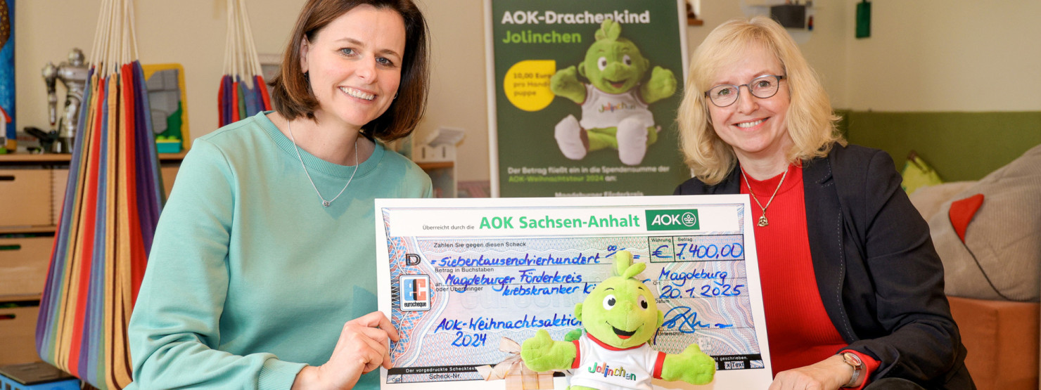 Sandra Matz vom Magdeburger Förderkreis krebskranker Kinder e.V. , das AOK-Drachenkindes Jolinchen und Cornelia Schulz, Landesrepräsentantin der AOK Sachsen-Anhalt bei der Übergabe des Spendenchecks 