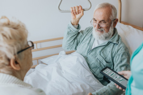 Ein Senior mit Dekubitus liegt in einem Bett mit Dekubitusmatratze.