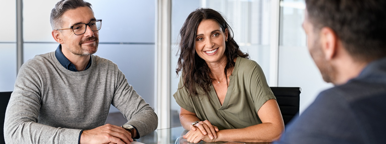 Zwei Beschäftigte wird von ihrer Führungskraft in einem Gespräch motiviert.