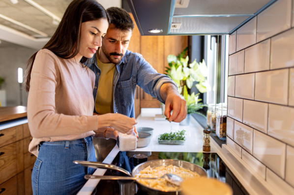 Paar kocht zusammen in der Küche und würzt die Speisen