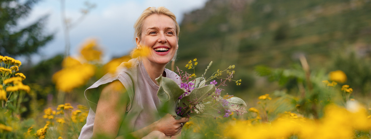 Eine junge Familie pflückt einen Strauß Blumen auf einer Blumenwiese