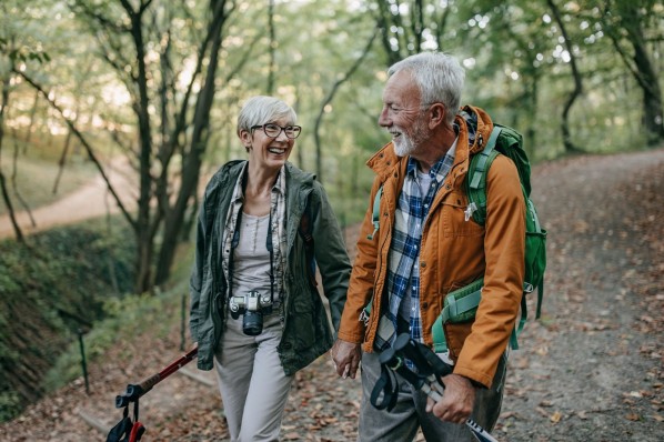 Ein etwa 70-jähriges Paar beim Wandern in der Natur. 