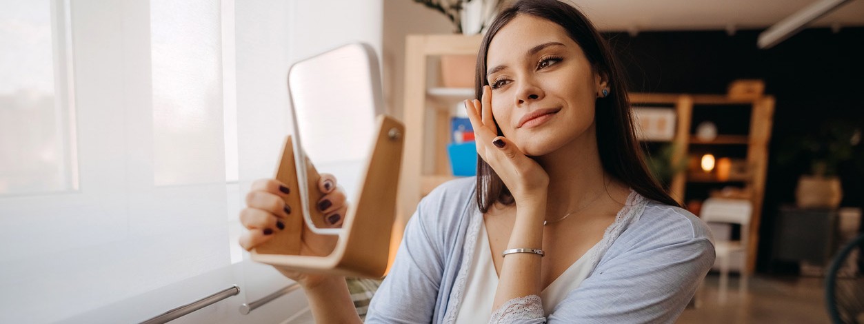 Eine Frau bewundert ihre Haut nach dem Dermaplaning