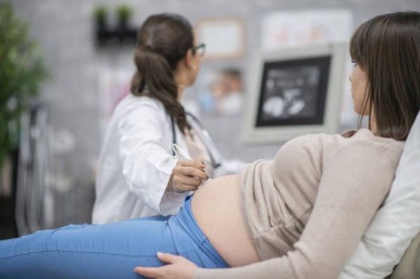 Junge Frau bekommt einen Ultraschall in der Arztpraxis. Sie ist schwanger.