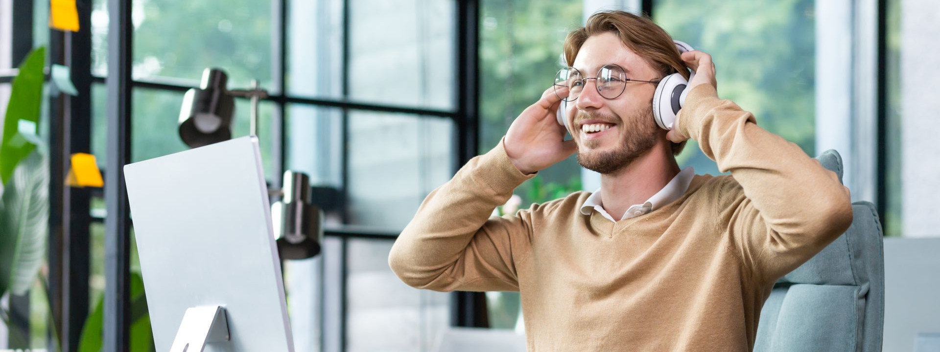 Ein Mann hört mit Kopfhörern den BGM-Podcast der AOK Sachsen-Anhalt