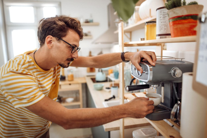 Ein Mann bereitet Kaffee mit Siebträgermaschine zu