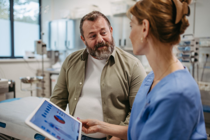 Ärztin berät sich mit übergewichtigen Patienten und bespricht das Testergebnis in der Arztpraxis.