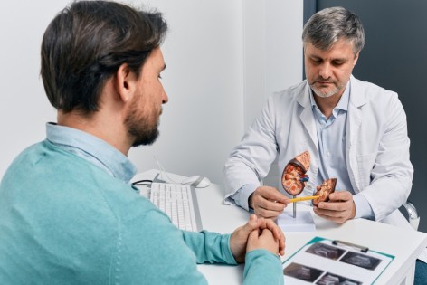 Ein Urologe berät einen Patienten zum Vertrag bei chronischer Niereninsuffizienz.
