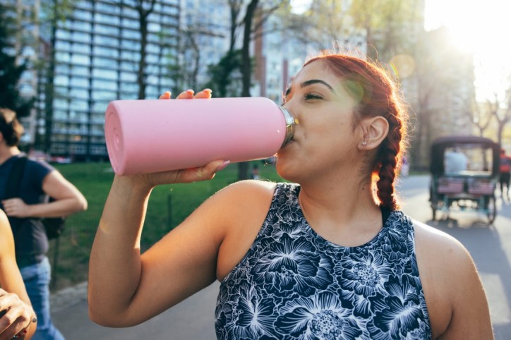 Eine Frau beugt bei heißen Temperaturen einer Dehydration vor