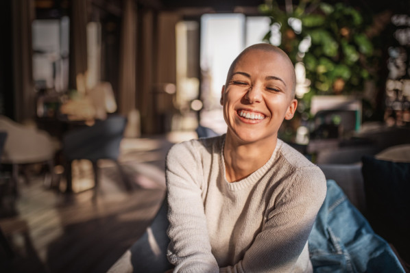 Junge Frau, Ende 20, mit strahlendem Lächeln durch Zahnvorsorge. - AOK Sachsen-Anhalt fördert Zahngesundheit mit Zuschüssen zur professionellen Zahnreinigung.