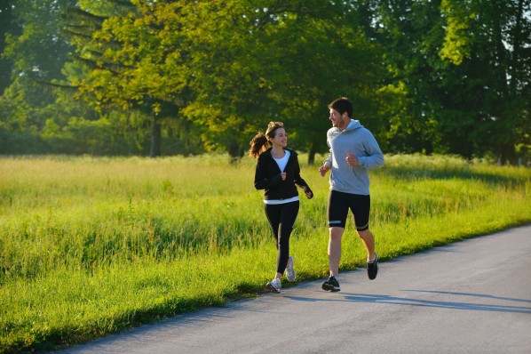 Junges Pärchen joggt gemeinsam durch den Park.