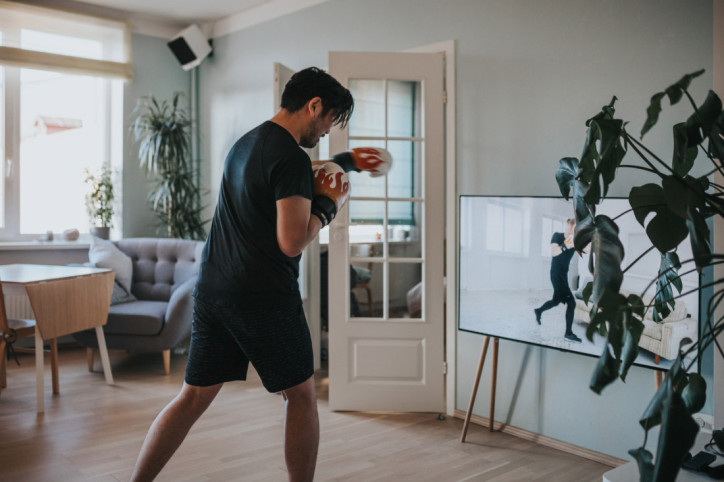 Ein Mann übt Boxen vor dem Fernseher