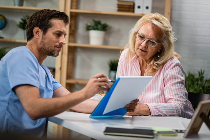 Male doctor explaining medical reports to his senior patient while having consultations at medical clinic.