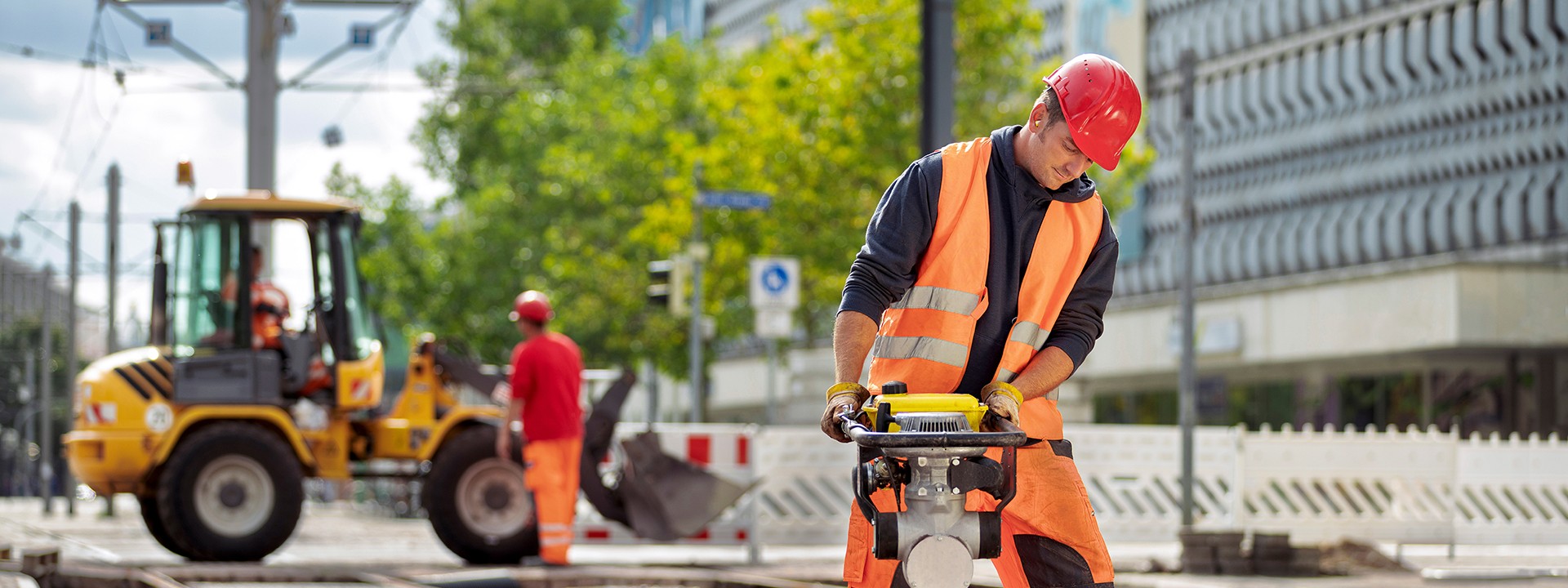 Ein Arbeiter arbeitet mit einem Presslufthammer auf einer Baustelle