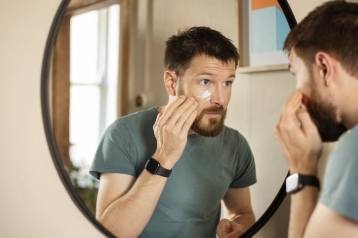 Ein Mann mit normaler Haut pflegt sein Gesicht