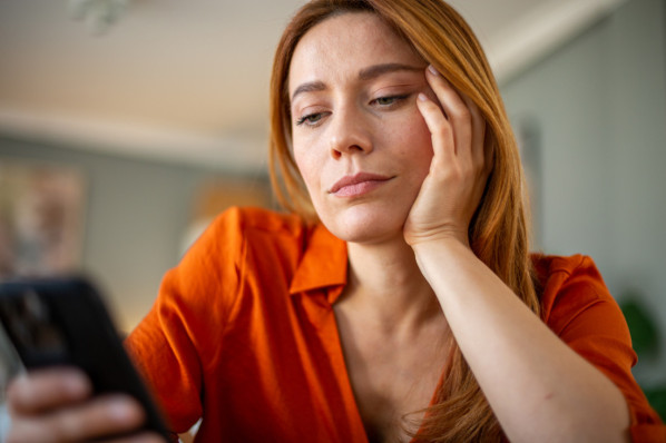 Frau wartet Nachricht am Telefon