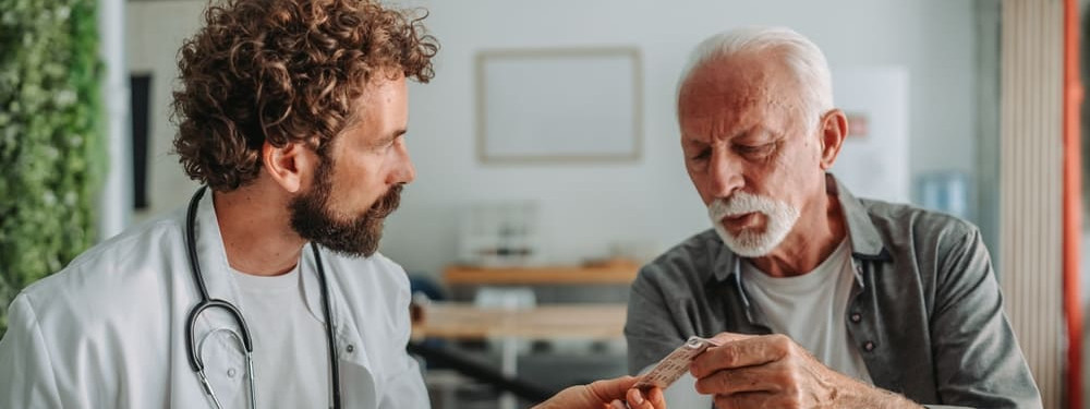 Ein Arzt verschreibt einem älteren Patienten Blutverdünner