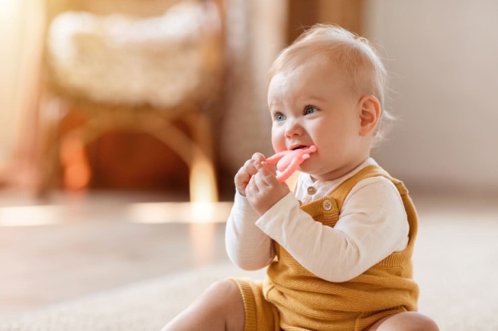 Ein zahnendes Baby kaut auf einem Beißring