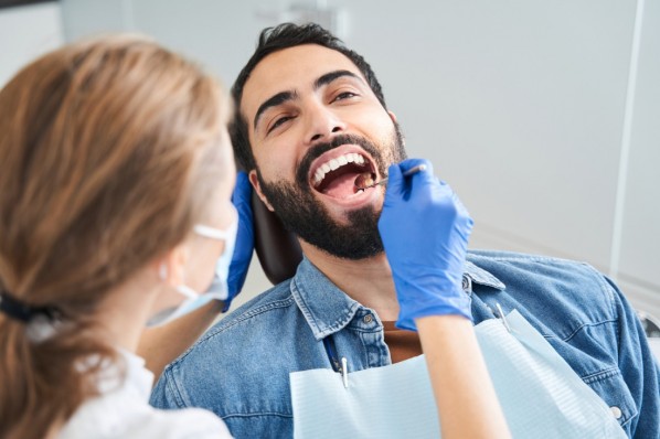 Mann Mitte 40 bei der Zahnvorsorge bei seiner Zahnärztin