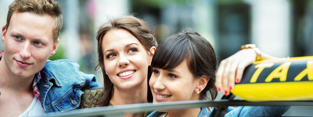 Junge Leute stehen an einem Taxi