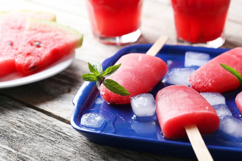 Watermelon popsicle on tray on grey wooden table