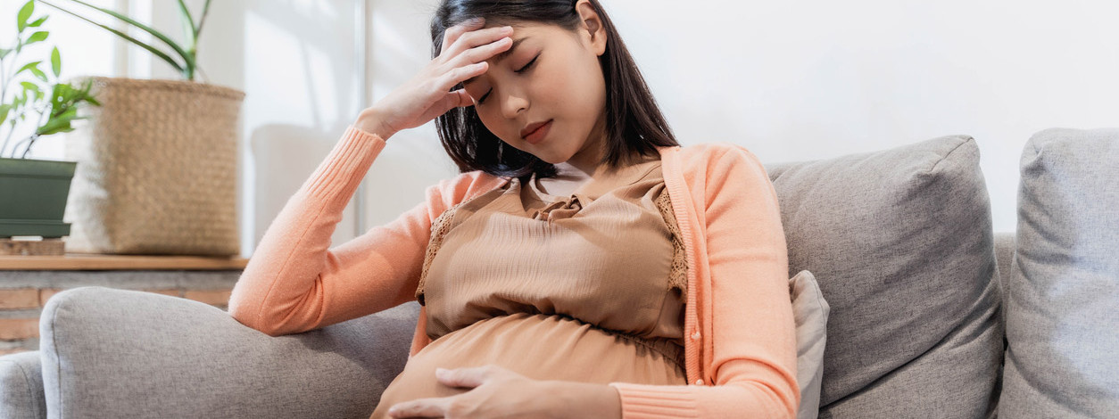 Eine schwangere Frau fühlt sich aufgrund einer CMV-Infektion unwohll