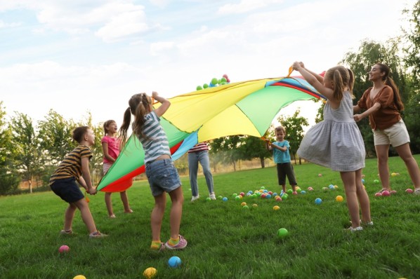 Kinder spielen auf einer Wiese. 