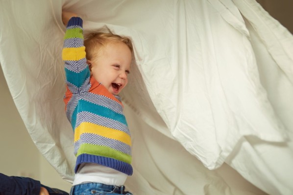 2-jähriger Junge tobt unter der Bettdecke