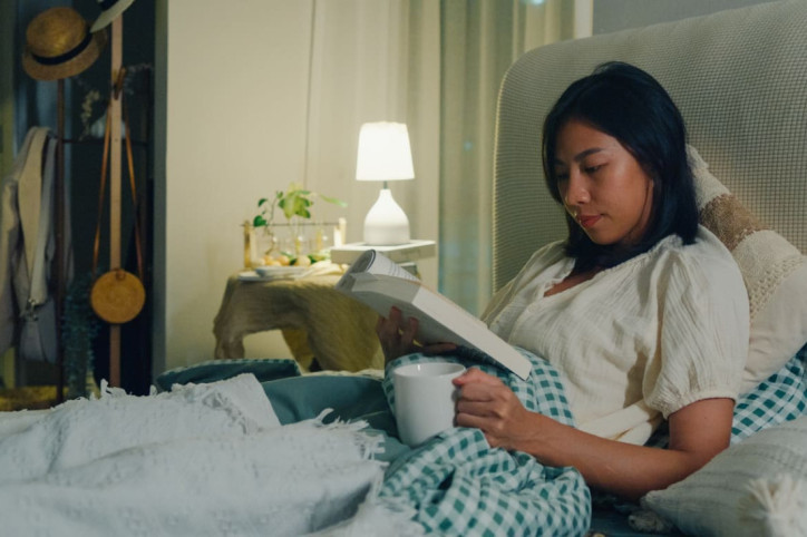 Frau hält Schlafhygiene im Bett ein.