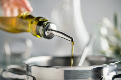 Öl wird in einen Edelstahltopf gegossen.