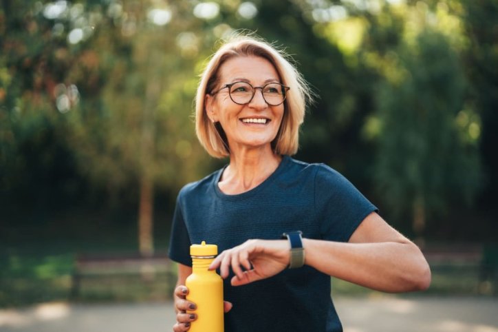 Ältere Sportlerin nutzt beim Funktionstraining eine Smartwatch