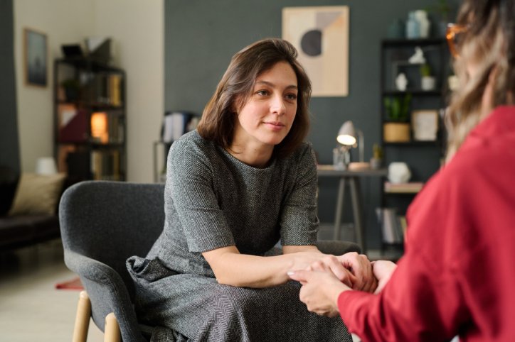 vertrautes gespräch zwischen 2 Frauen, die sich an den Händen halten