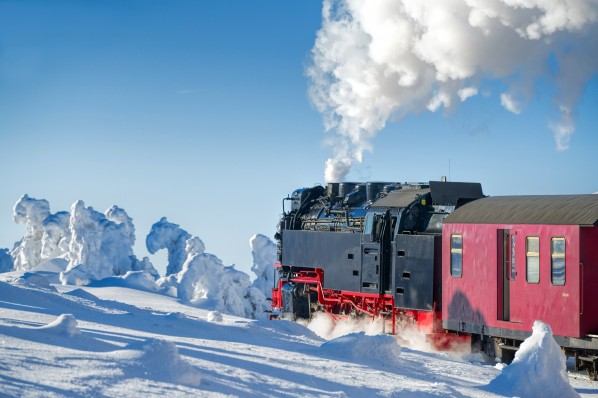 Brocken-Bergbahn fährt durch schneebedeckte Landschaft.