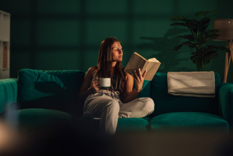 Eine Frau mit Nachtblindheit liest ein Buch bei schlechten Lichtverhältnissen