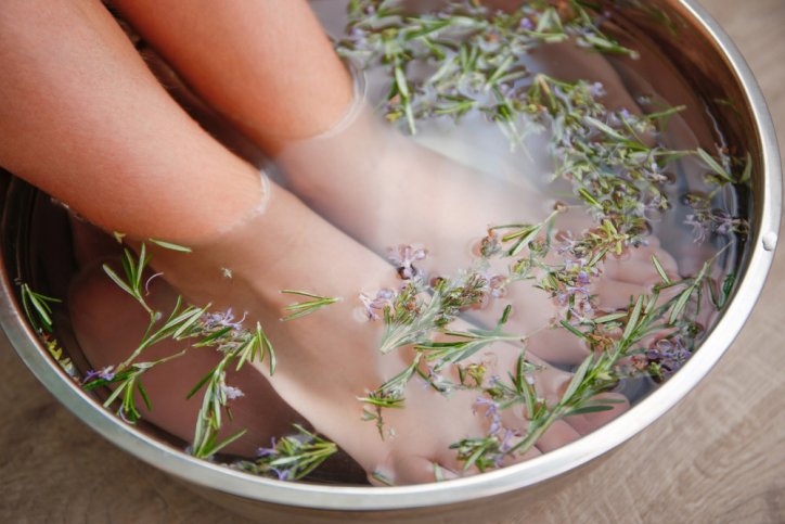 Ein Fußbad mit Rosmarin wird zur Aromatherapie eingesetzt