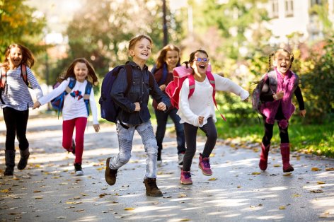 Erstklässler mit Schulranzen auf dem Weg zur Schule.