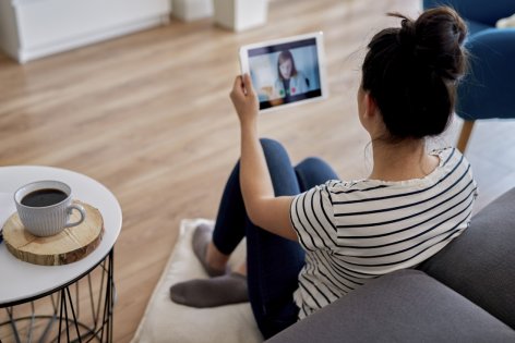 Eine Frau spricht über ein Tablet mit einer Ärztin.