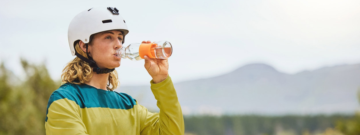 Eine Frau trinkt eine Elektrolytmischung beim Sport