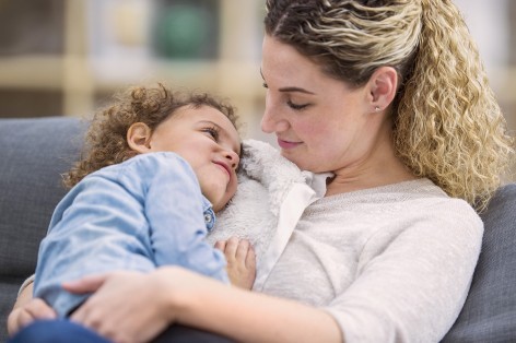 Tochter liegt auf Schulter der Mutter