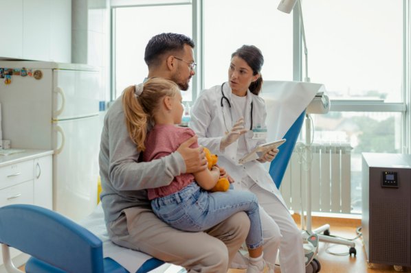 Ein Ärztin teilt einem Vater und seiner kleinen Tochter den Befund über das Reye-Syndrom mit