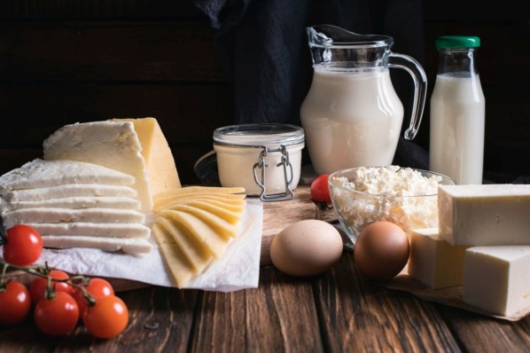 Frühstückstisch mit Käse, Milch, Eiern und frischen Tomaten,