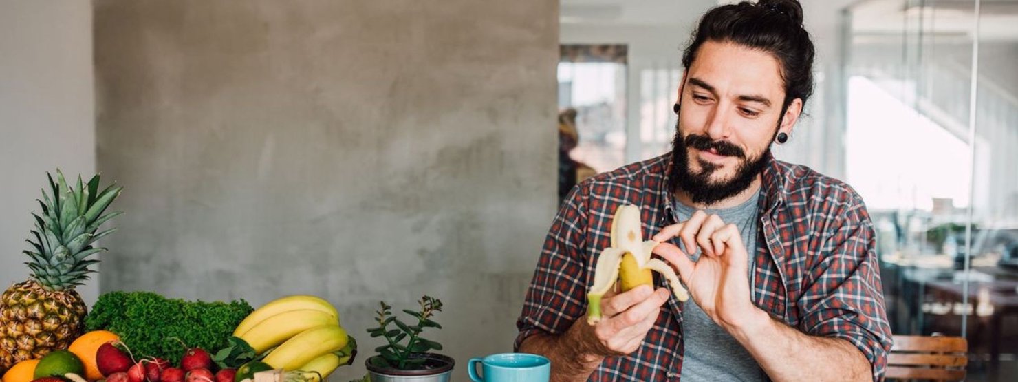 Eine ca. 25 jährige Frau mit Brille und langen Haaren isst einen Naturjoghurt mit Früchten.