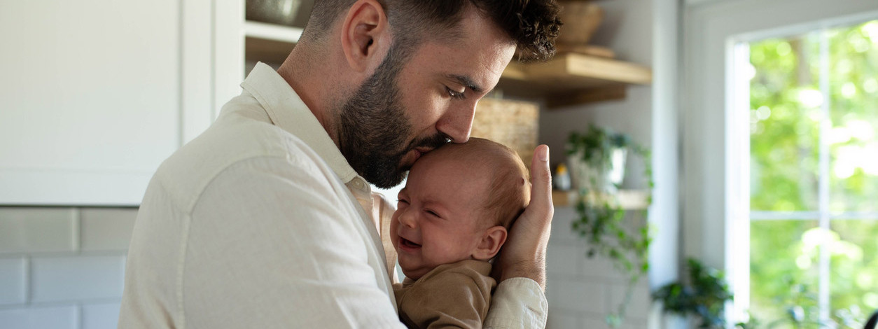 Ein Vater beruhigt sein Baby mit Dreimonatskoliken