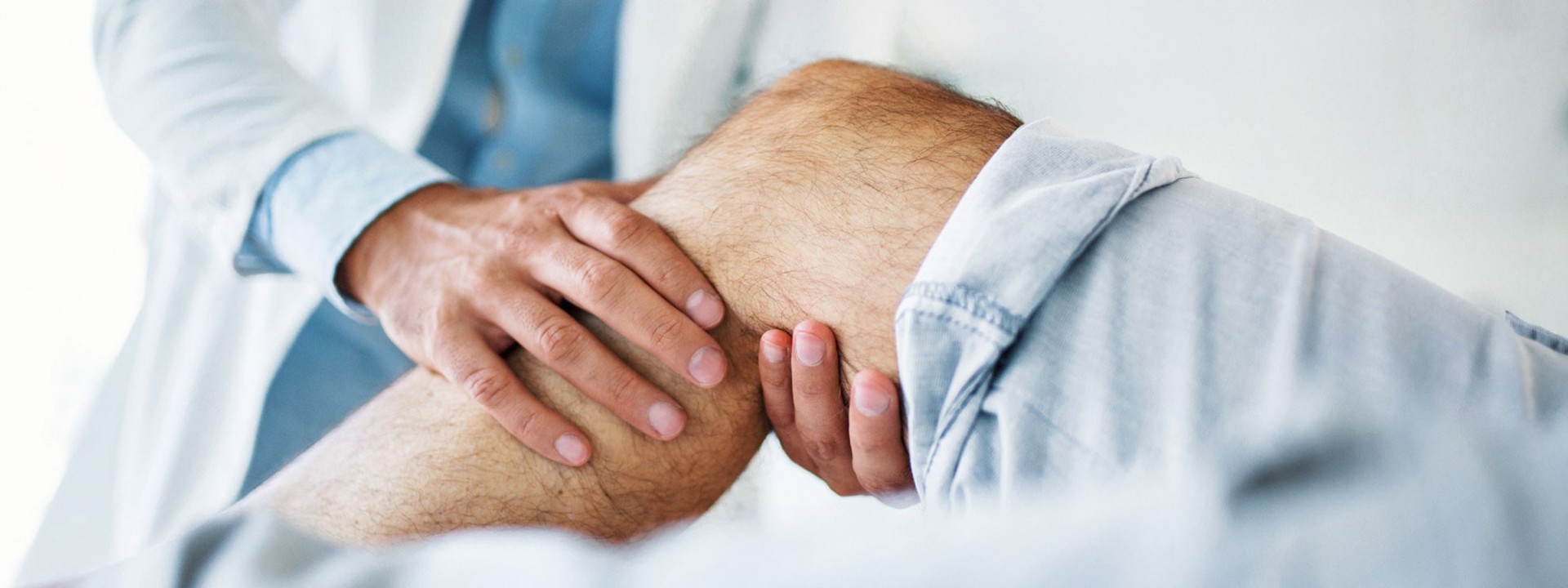 Ein Mediziner untersucht die Beine eines Patienten