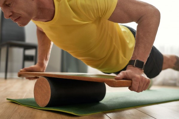 Mann macht Liegestütze auf balance Board