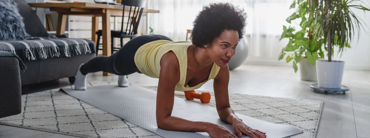 Frau führt funktionelles Training Zuhause durch