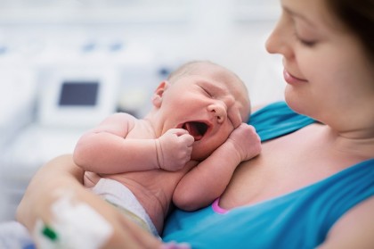 Frau mit Säugling auf Brust.