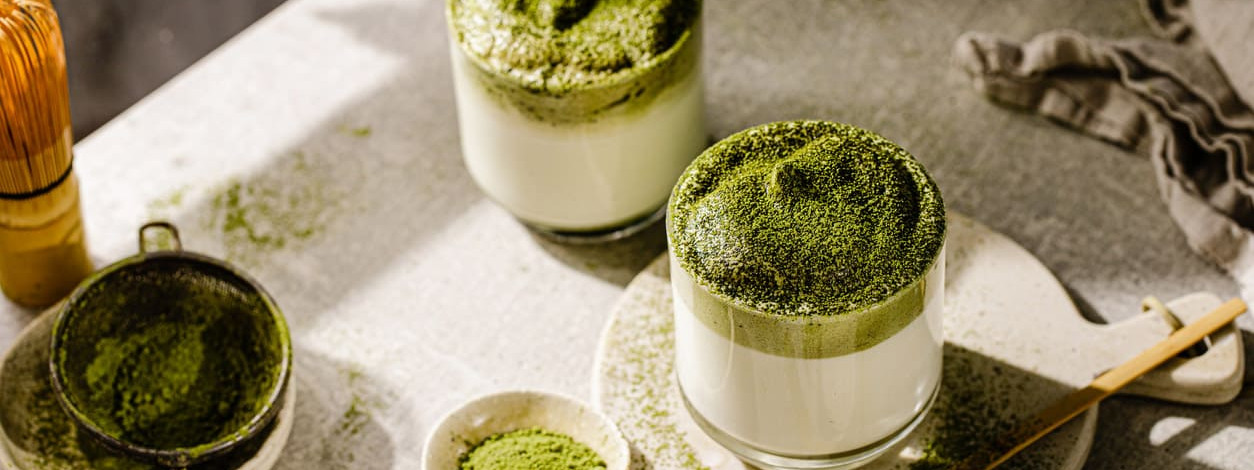 Matcha-Pulver und zwei Gläser Matcha-Latte